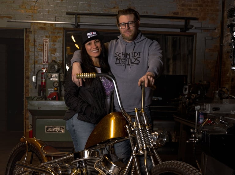 woman and man posing in front of a custom built motorcycle