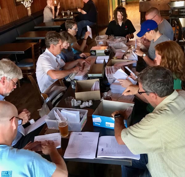 A group of people around a table covered in envelopes working