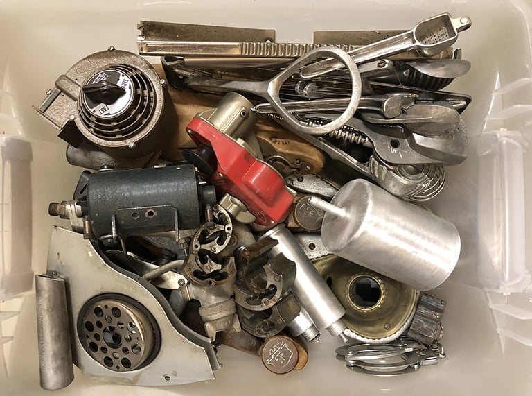Metal parts in a sculptor's workshop bin, image 1.