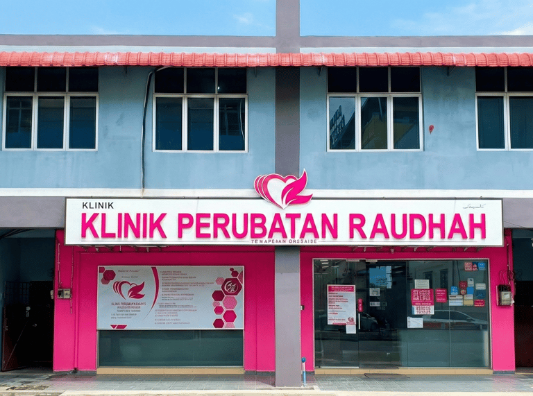 Exterior of Klinik Perubatan Raudah medical clinic building with pink signage and glass storefront.