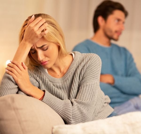 a man and woman sitting on a couch in a living room