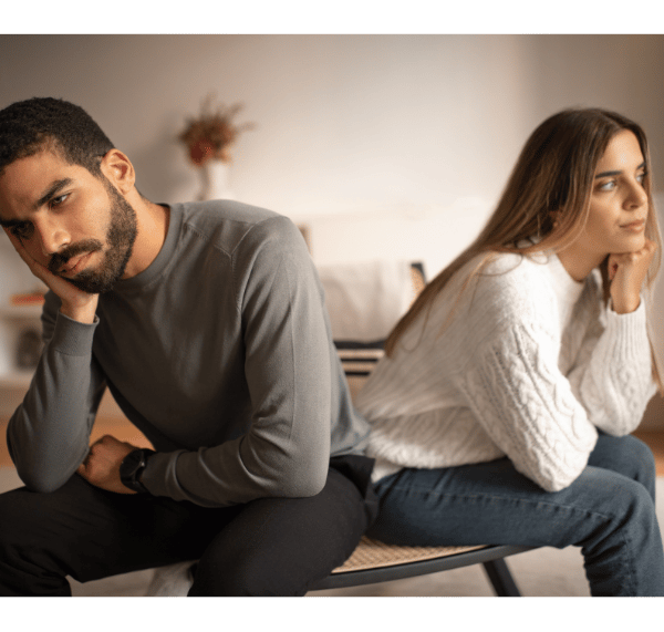 a man and woman sitting on a bench in a living room