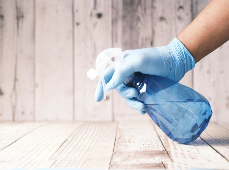 a person in gloves is cleaning a table