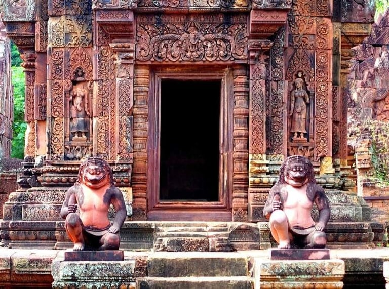 a group of monkeys sitting on steps leading to a doorway