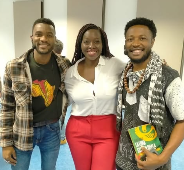 Dos hombres afros y una mujer afro de pie posando para la foto