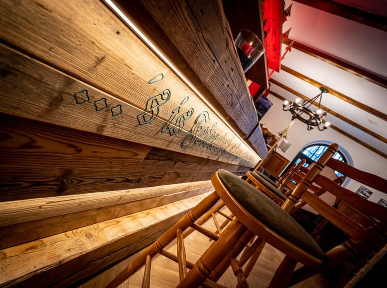 farbiger gefräster Schriftzug an einer Holzbar
