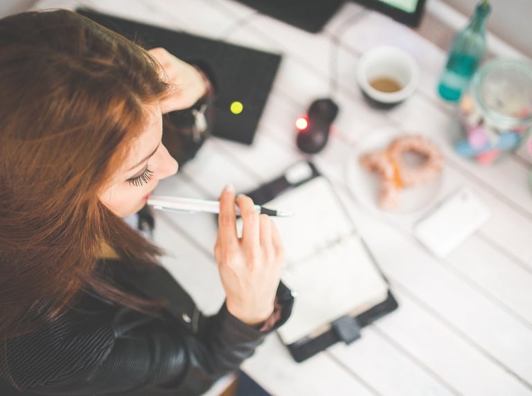 a woman sitting at a desk with a pen and a pen