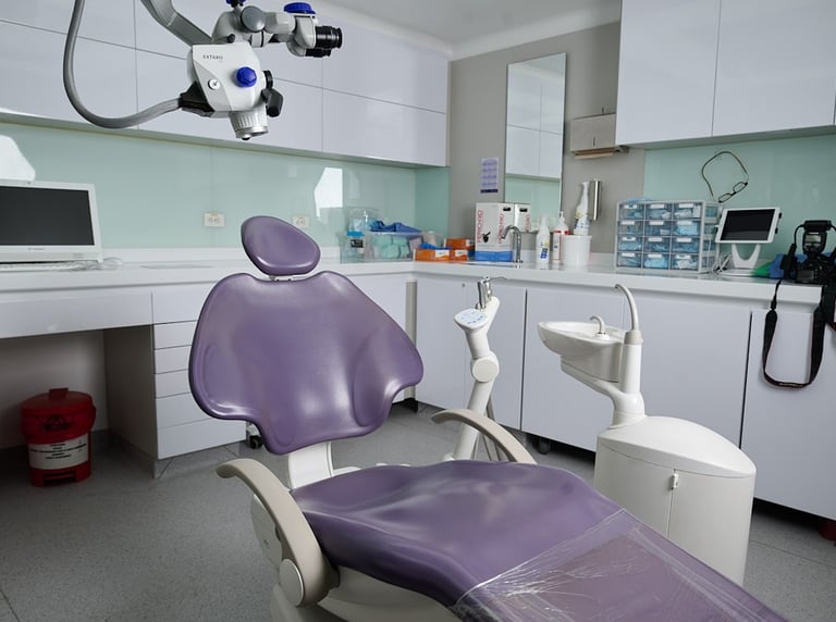 Modern dental office with treatment chair, surgical microscope, and medical equipment.