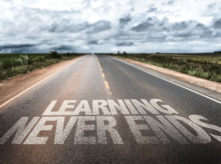 Endlose Straße mit Schriftzug „Learning Never Ends“ als Symbol für mein lebenslanges Lernen