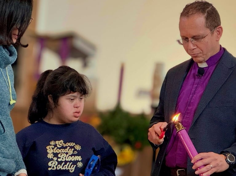 a priest holding a candle in a church