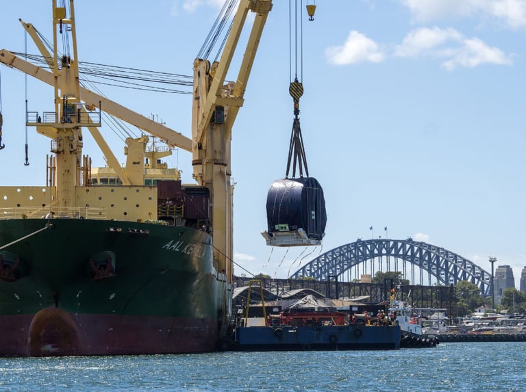 Unloading of TBM components from heavy lift ship to barge in Sydney Harbour