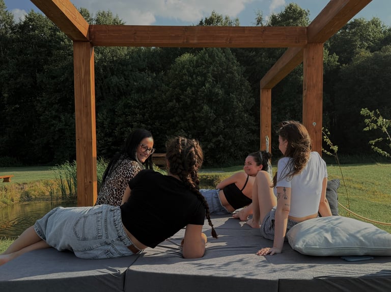 Cztery kobiete uśmiechają się do sibie na konstrukcji pod gołym niebem. Rodzinna atmosfera. 