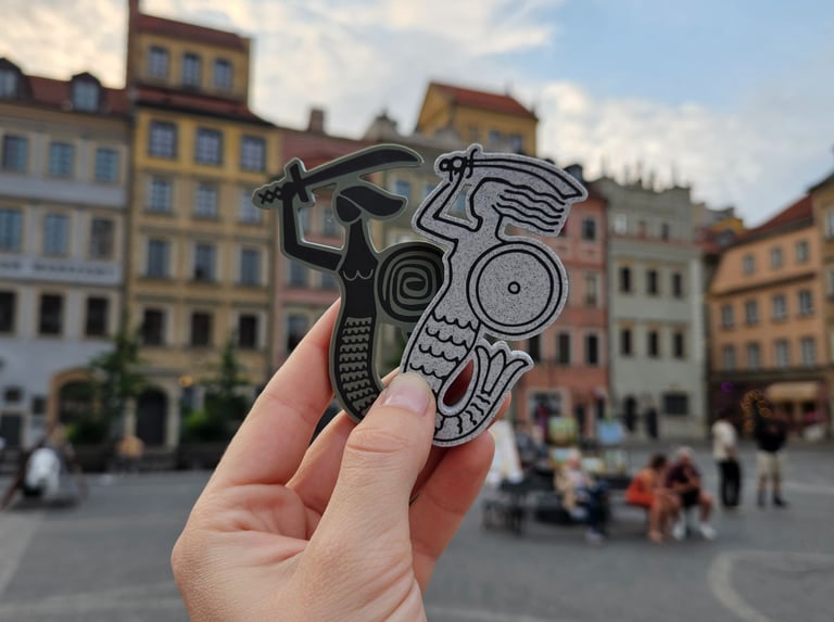 Dwie syrenki na tle rynku Starego Miasta w Warszawie