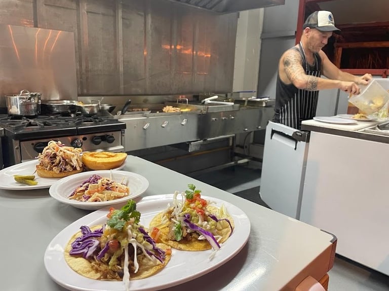 Fresh tacos, pulled pork sandwich and cole slaw. Barrel Bar & Grill restaurant kitchen.