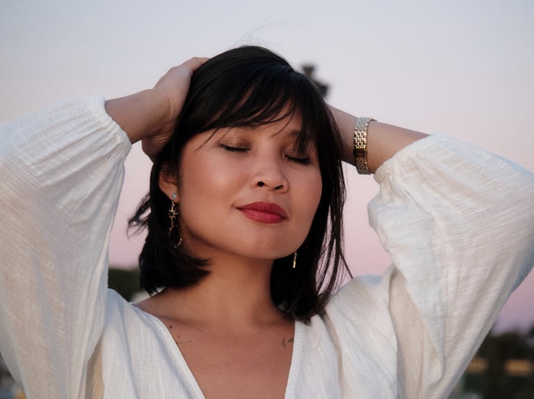 Modèle femme brune avec une chemise blanche sur un fond de ciel le soir