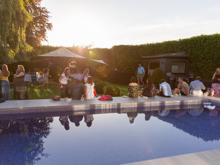 a group of people standing around a pool