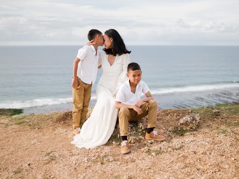 Ayunda family portrait standing on the cliff at Melasti Beach Bali during a relaxed family photography session.