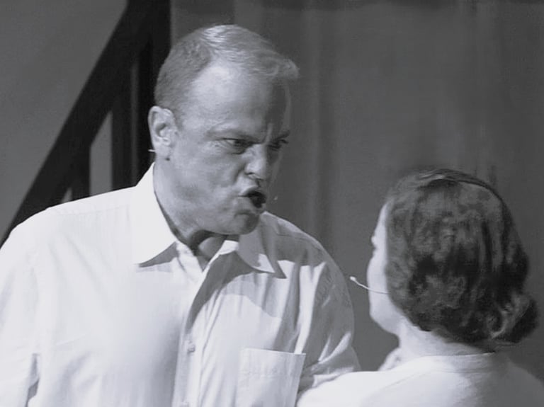 A very angry man is yelling a young woman.