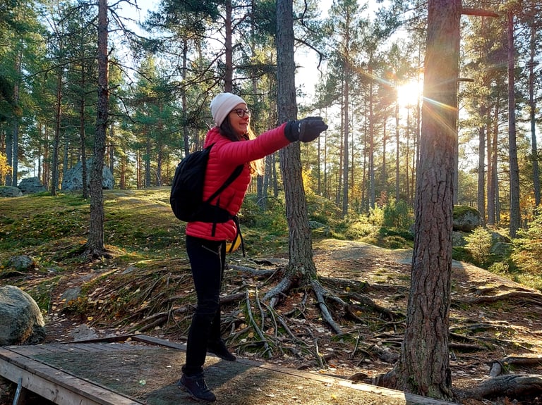 a woman in a red jacket throwing a frisbee