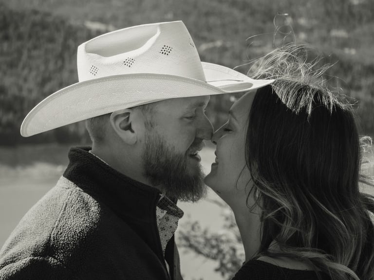 a man and woman kissing in a mountain
