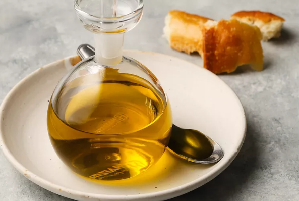 a bottle of olive oil on a plate with bread and bread