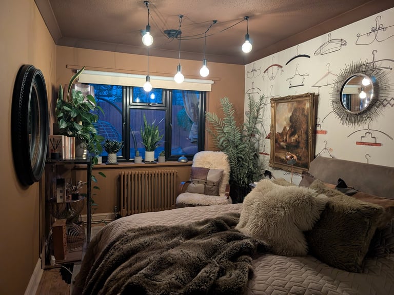 Cozy eclectic bedroom with earthy brown walls, faux fur bedding, indoor plants, and vintage decor.
