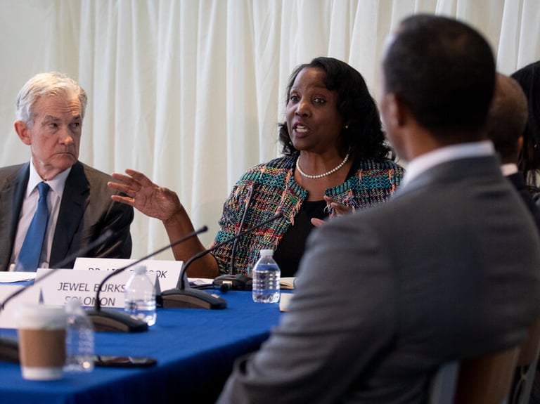 Lisa Cook speaks at a Federal Reserve roundtable discussion with Jerome Powell sitting nearby.
