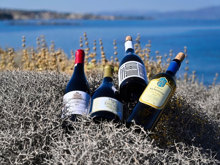 four greek bottles of wine on a thyme area