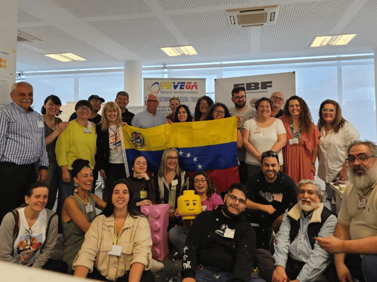 Grupo de personas mirando a la cámara, sosteniendo la bandera de Venezuela.