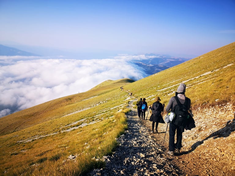 Prospettiva di un gruppo in escursione che scende dalla Cima del Monte Vettore