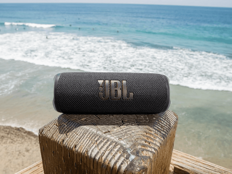 a speaker with a bluetoothed speaker on a wooden fence