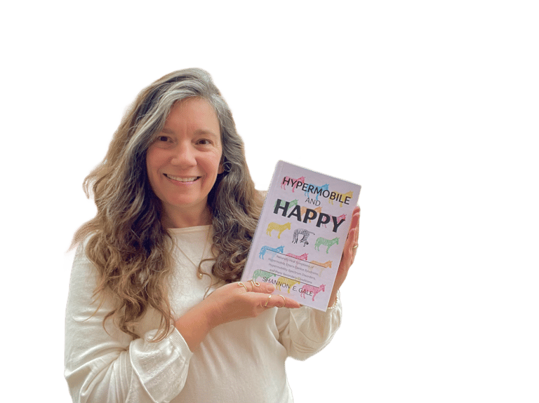 smiling woman with long brown hair and white sweater holding a book