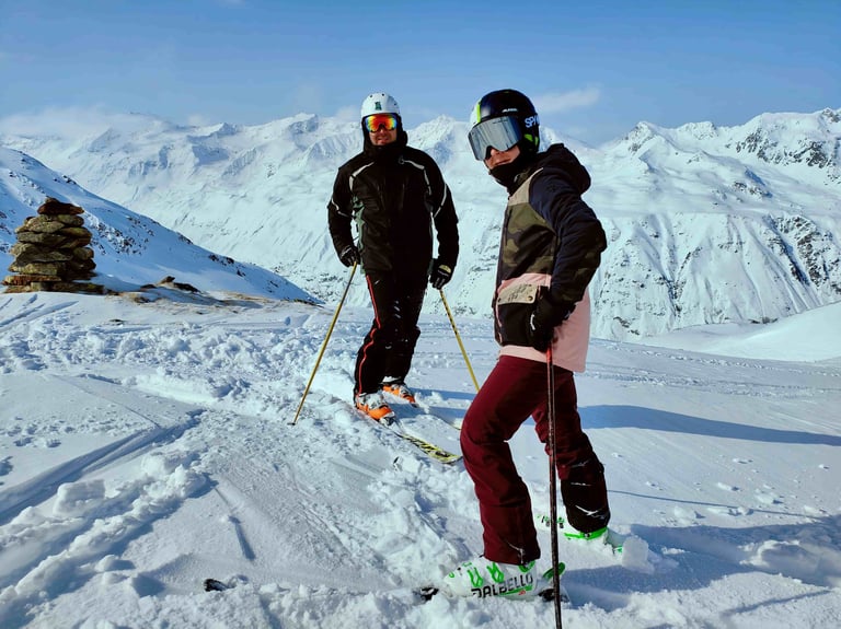 two people standing on skis in the snow