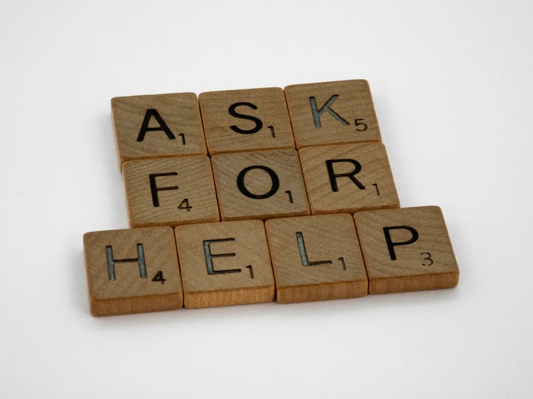 Scrabble tiles spelling ask for help on wooden surface, psychological counseling