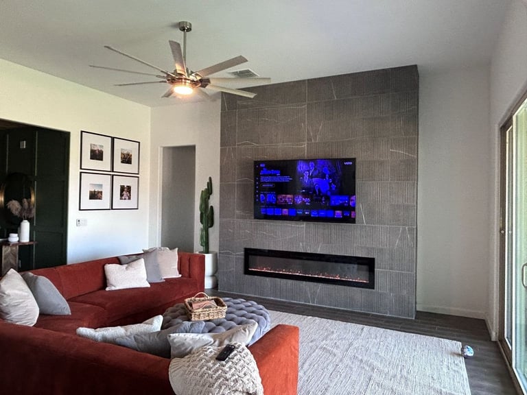 Living room with mounted TV and custom electric tile fireplace.