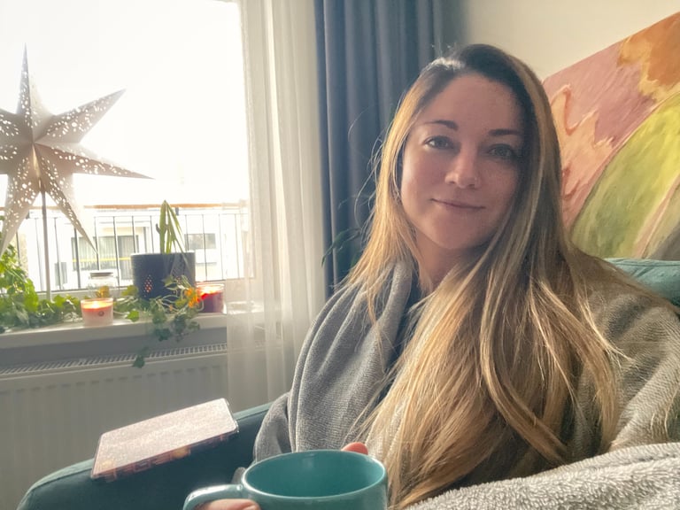 A picture of Christy sitting in her office with a cup of coffee and a warm welcoming attitude.