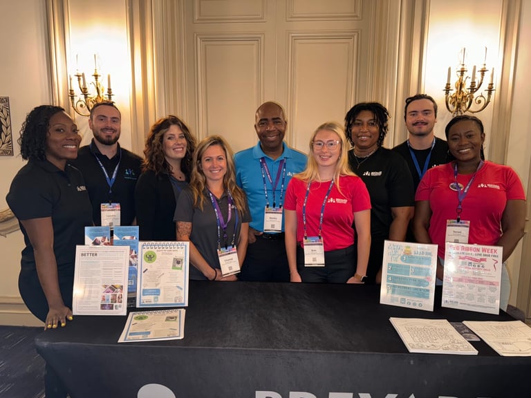 a group of people standing around an information booth smiling 