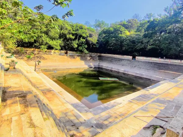 Amrita Sarovar, a symmetrical stepped pond at Nandi Hills, surrounded by stone steps and greenery