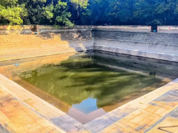 Amrita Sarovar, a symmetrical stepped pond at Nandi Hills, surrounded by stone steps and greenery
