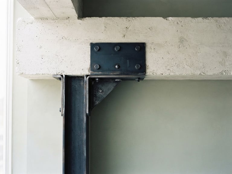 A minimalist architectural detail of concrete and steel joints intersecting cleanly under bright natural daylight, muted sage tones, 35mm lens.
