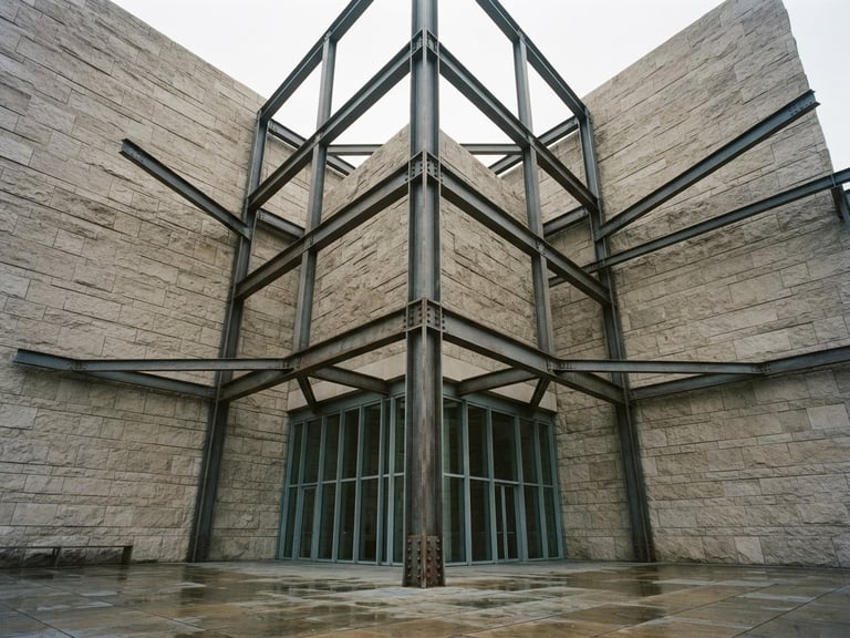 Symmetrical low-angle architectural photography of a limestone facade meeting a structural steel frame under soft overcast daylight, muted earth tones, 35mm