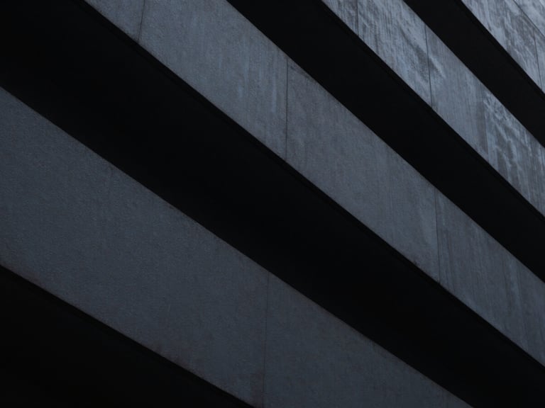 Abstract architectural geometry, low-key dramatic chiaroscuro, cool-toned ambient light with sharp high-contrast highlights, minimalist fine art photography, 35mm lens