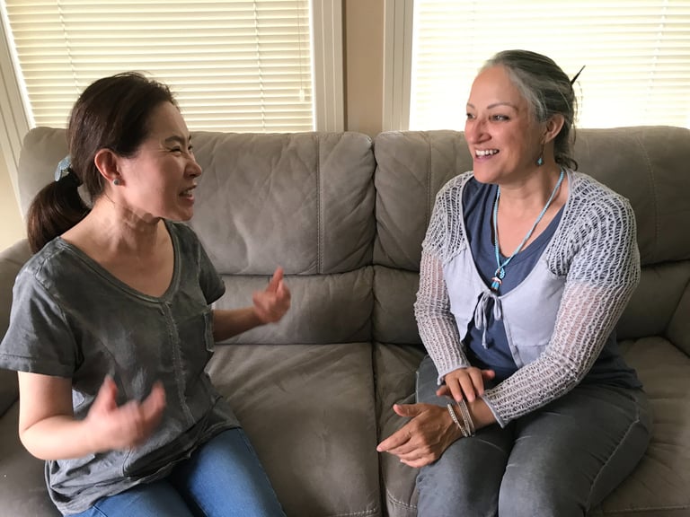Image of two women collaborating through open dialogue in a comfortable setting