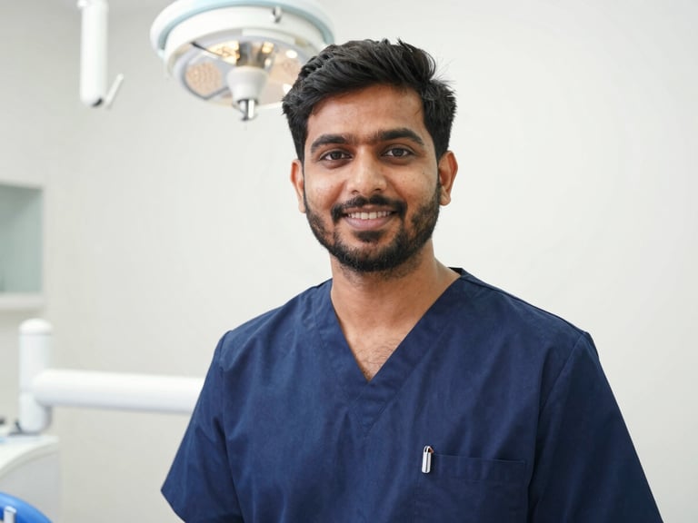 Professional medium portrait of Dr. Aman Sharma in clean clinical attire, bright natural daylight, warm and confident expression, sterile dental office background.