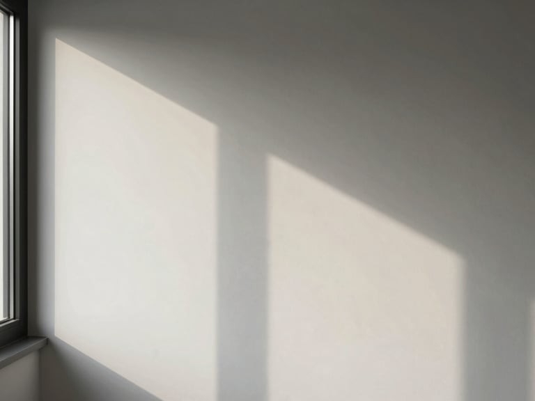 Corner of a room where a window casts a long, soft shadow across a white wall, showing the subtle transition of daylight. Editorial architectural photography, sharp details.