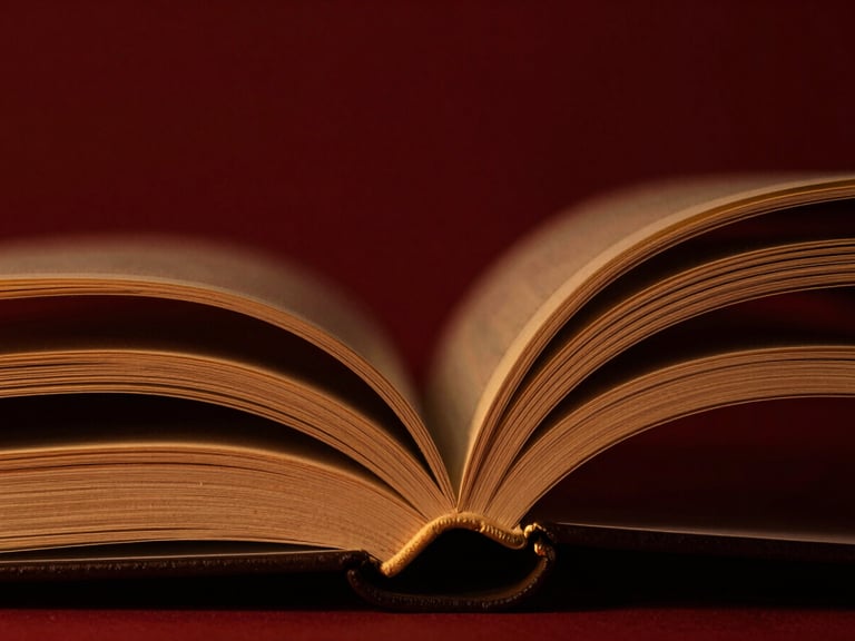 Macro close-up of heavy physical book pages showing texture of matte paper and gilded edges, dramatic low-key studio lighting with warm gold highlights