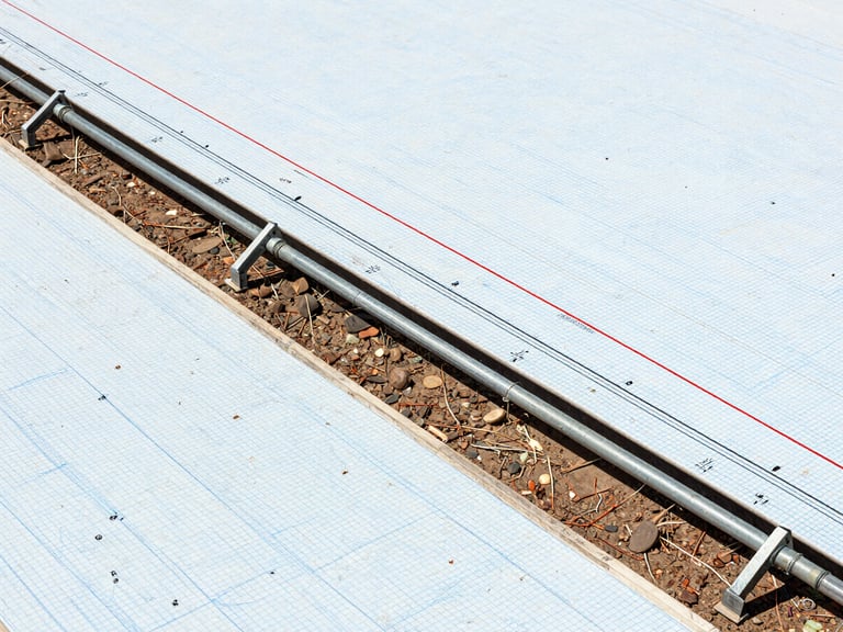 Detailed technical longitudinal profile drawing of a pipeline route, showing elevation lines, ground levels, hydraulic gradient lines, crisp blue grid background, engineering schematic style.