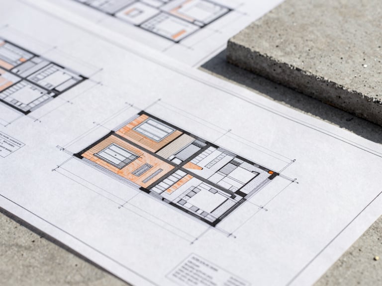 Detailed architectural drawings and blueprint schematics overlaid on raw concrete site materials, sharp technical crop, high-contrast crisp daylight