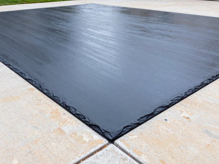 Wide angle architectural shot of a newly poured concrete driveway with a crisp broom finish, sharp joints, dark slate borders, wet gloss look under bright overcast sky, 24mm.