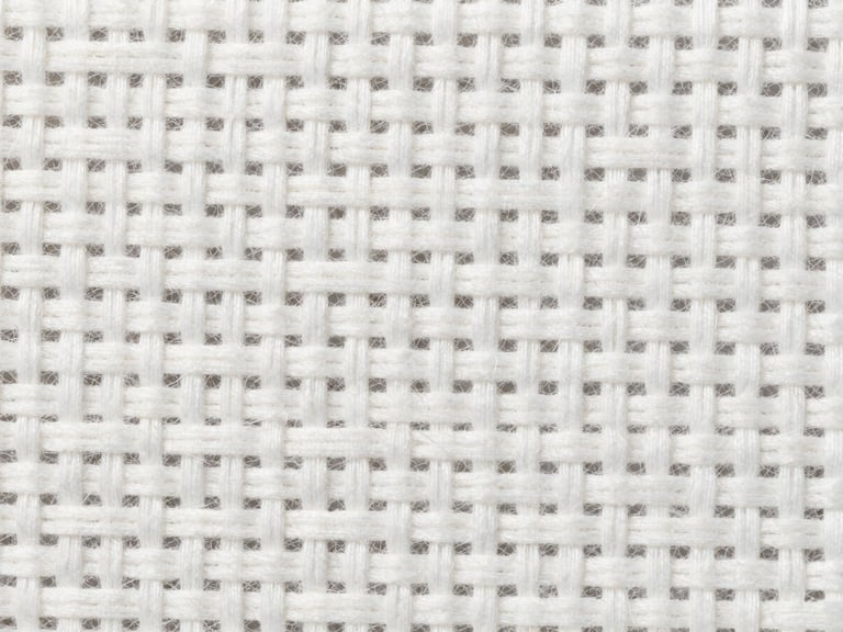 Macro photograph of high-density white cotton thread weave, showing the precise grid of the textile under bright neutral daylight